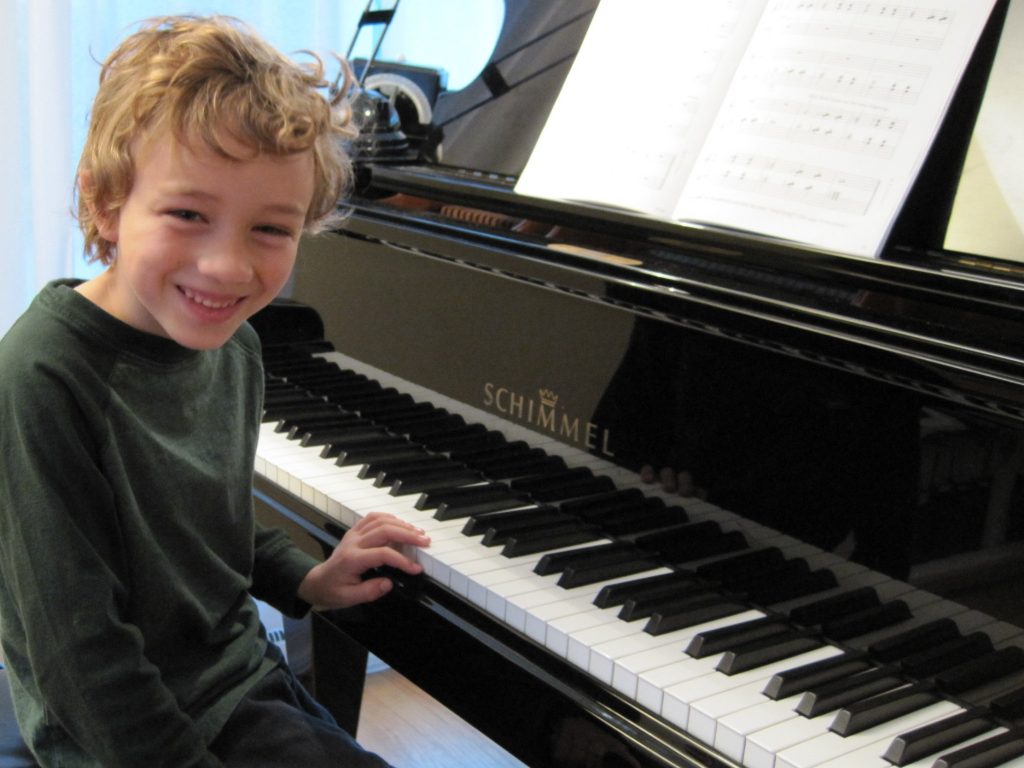 Young boy studying piano lessons