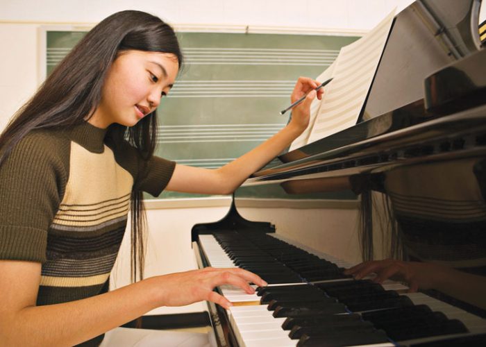 Asian girl studying piano