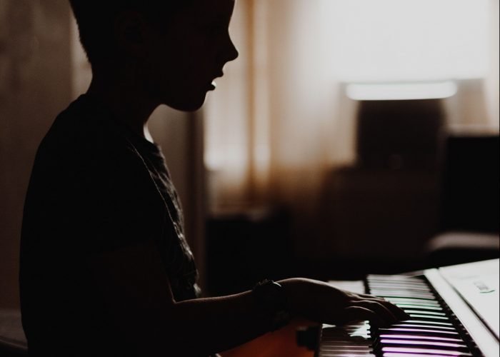 Boy playing piano in room